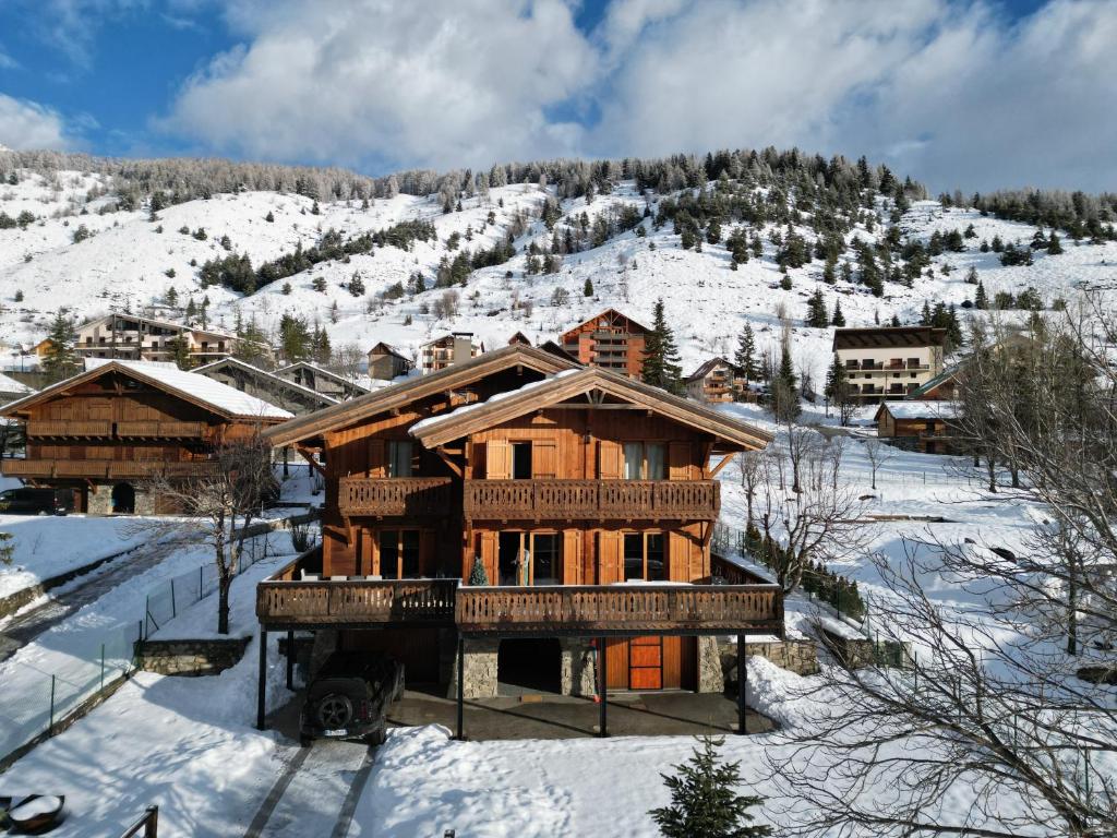 une cabane en rondins dans la neige avec une montagne dans l'établissement Chalet Les Rennes, à Saint-Étienne-de-Tinée