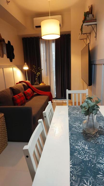 un soggiorno con tavolo, sedie e divano di My Humble Abode at Shore 3 a Manila
