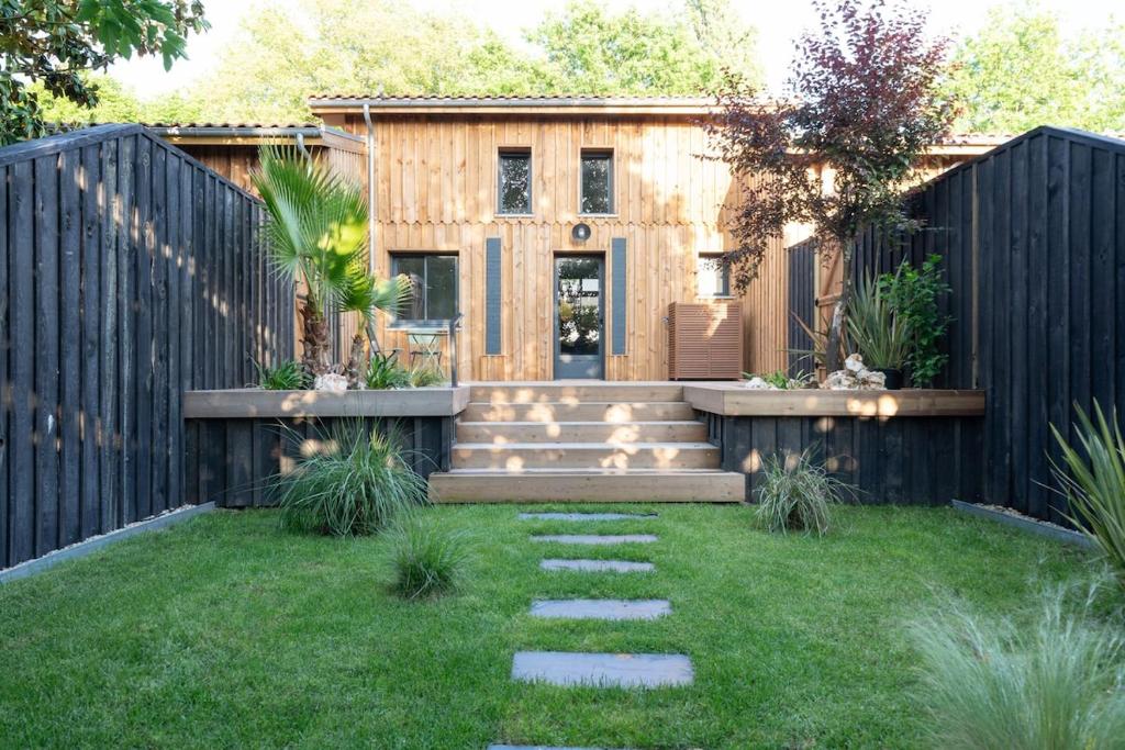 un cortile con una recinzione in legno e una casa di Maison du Ponton, bord de canal à Cazaux a La Teste-de-Buch