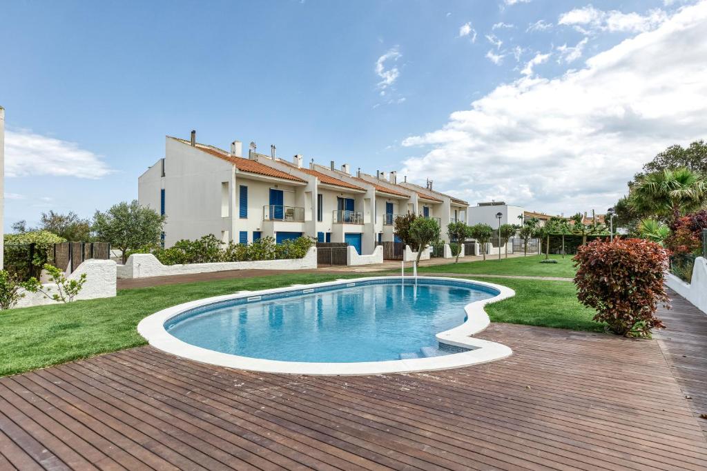 レスタルティットにあるOasis Premium Costa Bravaの家屋を背景にした庭のスイミングプール