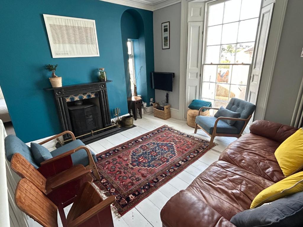 ein Wohnzimmer mit Couch und Kamin in der Unterkunft Seacroft - 3 Bed Georgian Listed Townhouse with Wood Burning Stove in Ilfracombe
