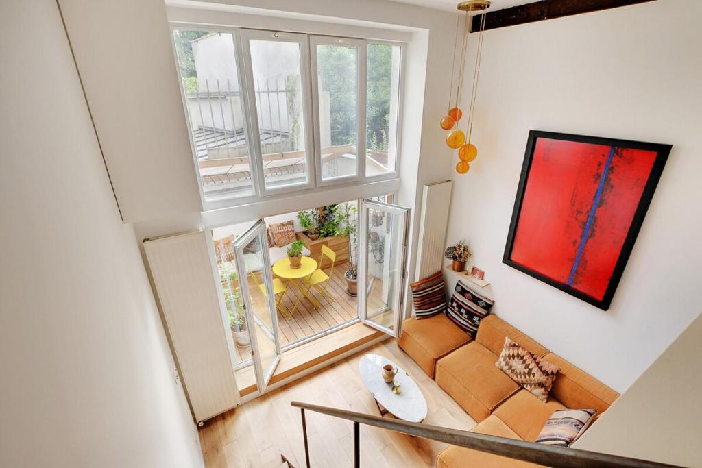 Cette suite dispose d'un salon avec une grande fenêtre. dans l'établissement Bright loft with terrace - Belleville, à Paris