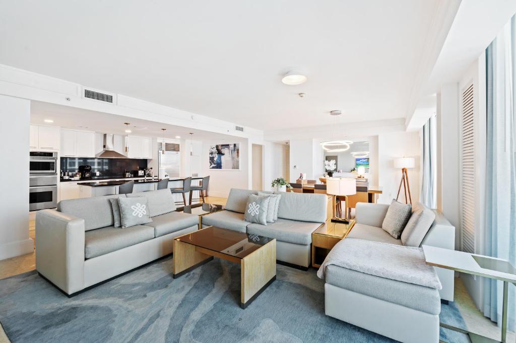 フォート・ローダーデールにあるRitz-Carlton Luxury Oceanview 3-Bedroom Residenceのリビングルーム(ソファ2台付)、キッチンが備わります。