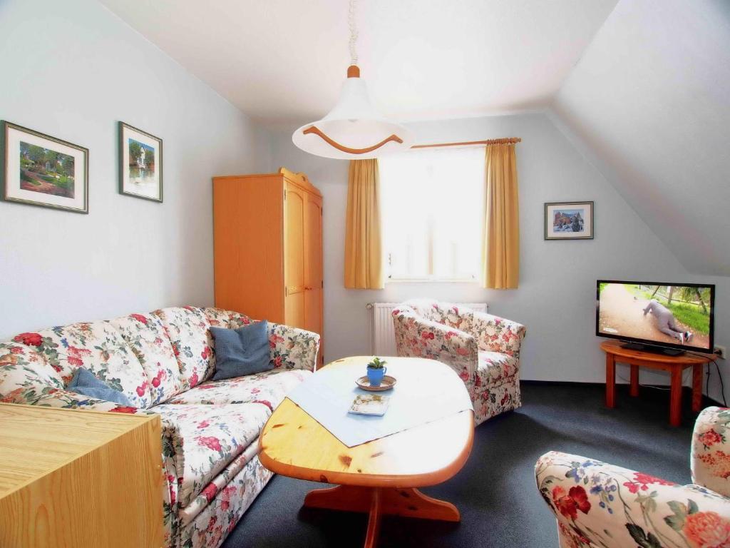 a living room with a couch and a tv at Gaestehaus-Bruhn-3 in Alkersum