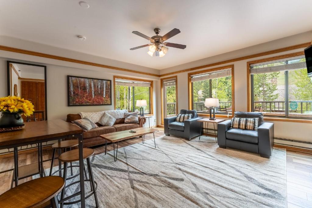un soggiorno con ventilatore a soffitto e finestre di Slopeside #2775 by Summit County Mountain Retreats a Keystone