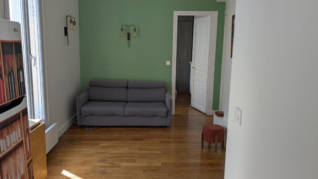 un salon avec un canapé et une chaise dans l'établissement Trocadéro- 2 pièces lumineux, à Paris