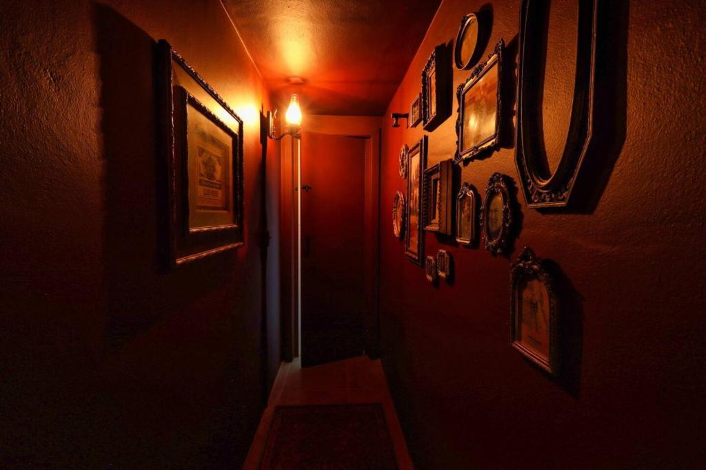 Una habitación oscura con un pasillo con cuadros en las paredes. en 1920s Speakeasy, Horses Hot Tub 5mi to Beach, en Vero Beach