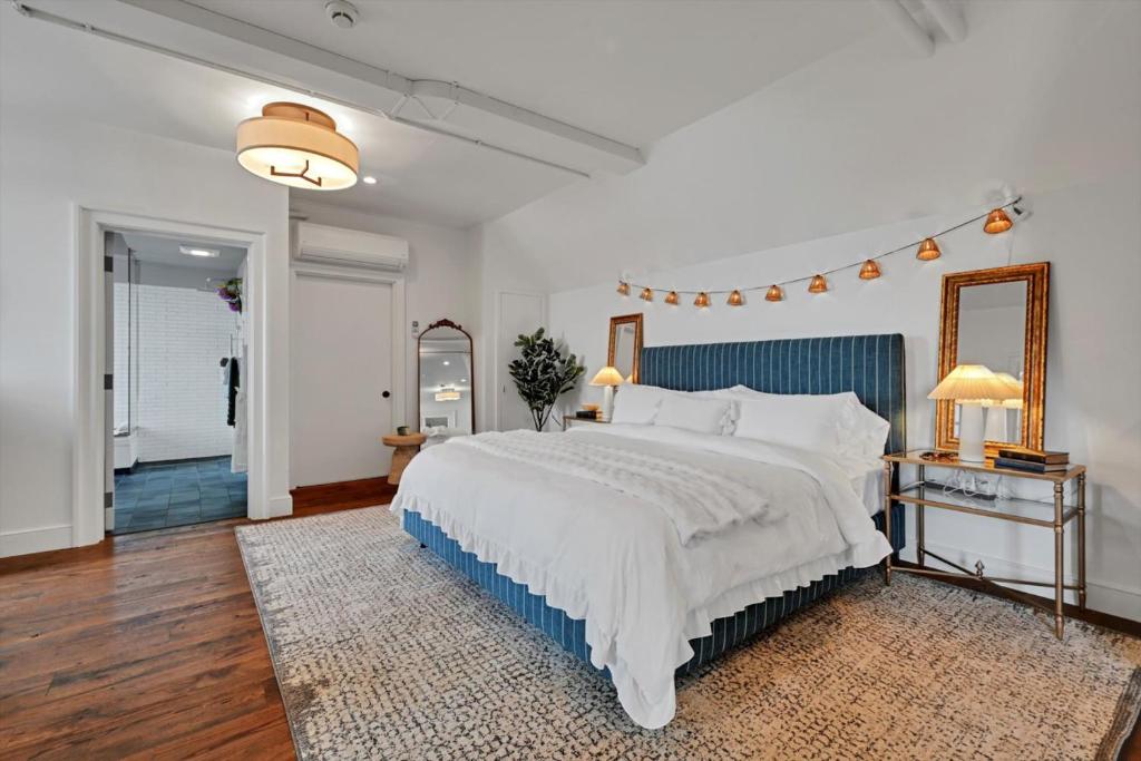 ein Schlafzimmer mit einem großen weißen Bett und einem Spiegel in der Unterkunft The Boat House Water Views Sunsets in York