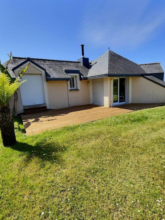 une maison avec une grande arrière-cour et une terrasse en bois dans l'établissement Belle maison vue sur mer, à Penvénan