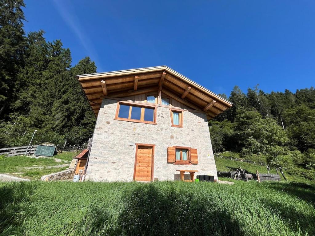 a small stone house with a wooden roof at Mountain Chalet Splazoi in Strembo