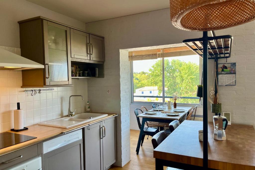 une cuisine avec une table et une salle à manger dans l'établissement Evasion surf & sunset - Parking Gratuit, à Les Sables-dʼOlonne