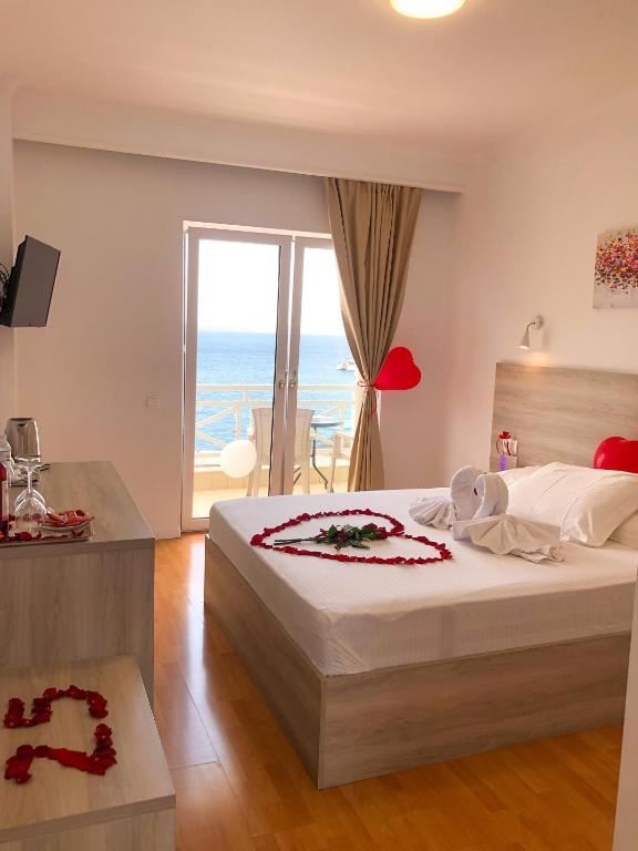 a bedroom with a bed with a view of the ocean at Sun N Blue Hotel in Sarandë
