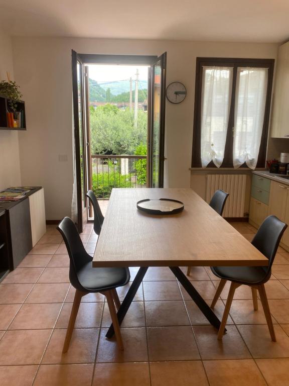 a dining room with a wooden table and chairs at Gardasweethome in Garda
