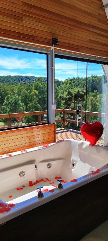 a large bath tub in a room with a large window at Cabana Santa Cruz 2 in São Francisco de Paula