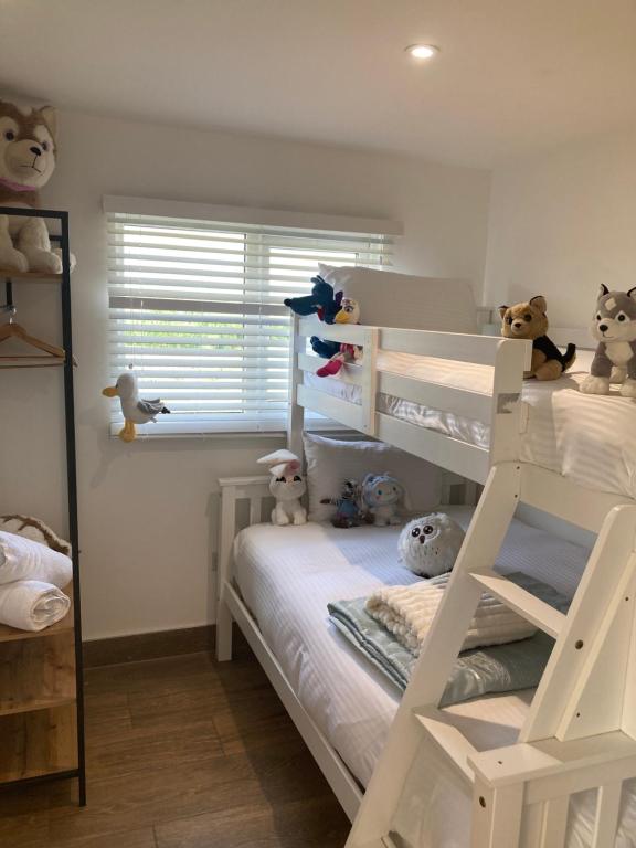a bedroom with two bunk beds with stuffed animals at Chalet K94 - Sunset View in Camber