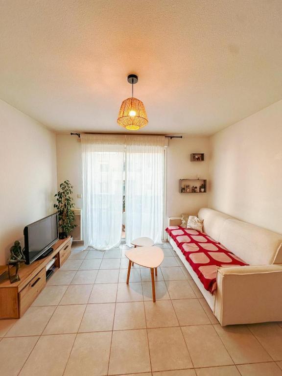 un salon avec un canapé et une télévision dans l'établissement Appartement 2 pièces, à Saint-Laurent-du-Var