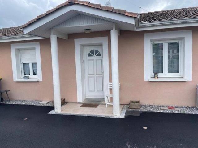 Maison rose avec une porte blanche et deux fenêtres dans l'établissement Maison familiale 4 chambres, à Gujan-Mestras