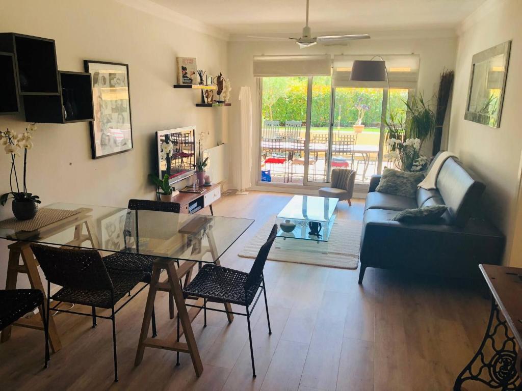 un salon avec un canapé, une table et des chaises dans l'établissement ANTIBES, 85 m2, ground floor, large wood terrace, à Antibes