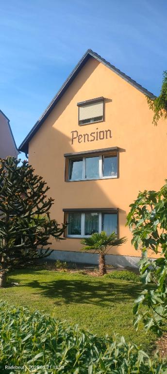 a tan building with the word permission on it at Pension Kaden in Dresden