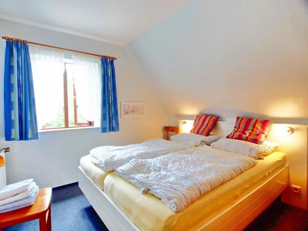 a large bed in a room with a window at Gaestehaus-Bruhn-6 in Alkersum