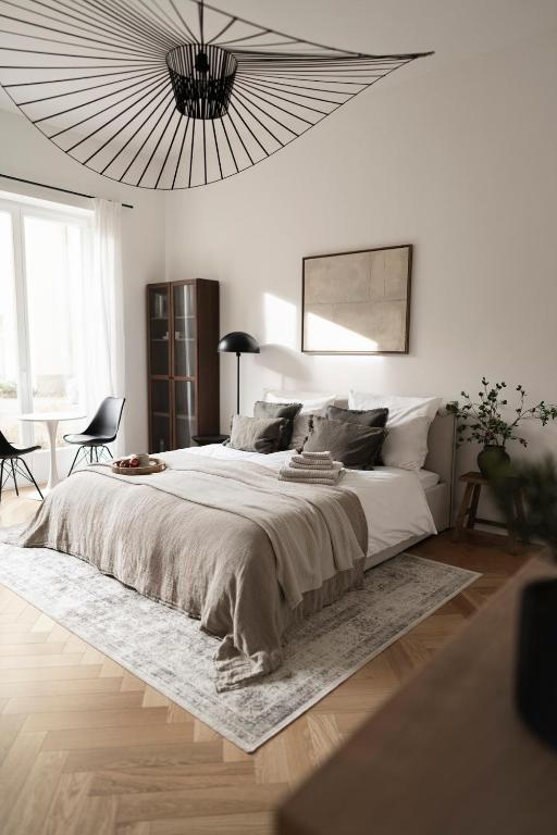 a white bedroom with a large bed and a chandelier at Design Apartment with Garden in Berlin