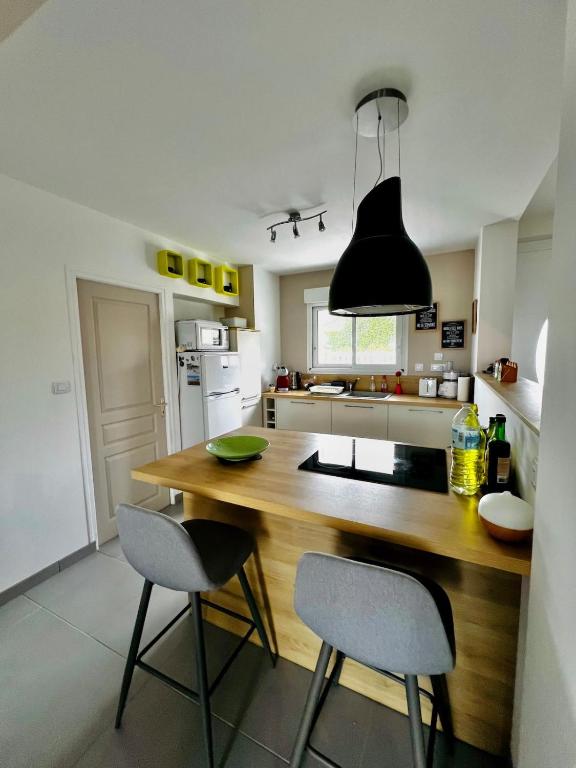 une cuisine avec une table en bois et deux chaises dans l'établissement Pretty house for 6 pers baby, à Barneville-Carteret