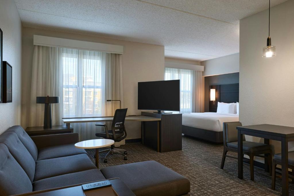 a hotel room with a bed and a living room at Residence Inn by Marriott Tallahassee Universities at the Capitol in Tallahassee