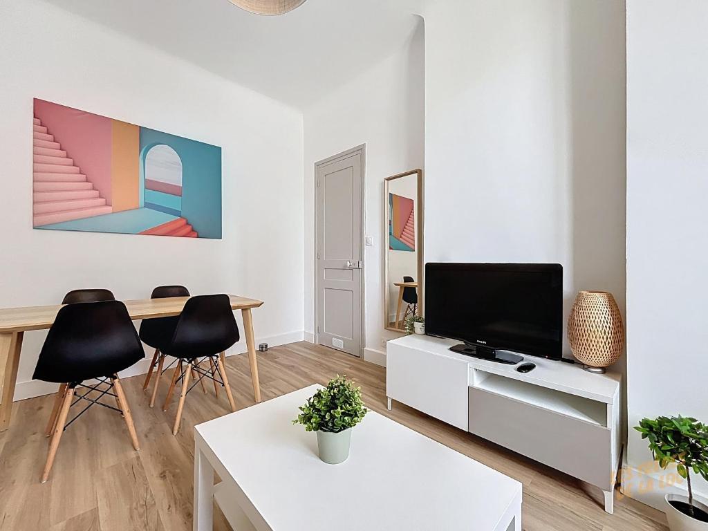 un salon avec une télévision et une table dans l'établissement Appartement proche des Plages et du Vélodrome - Les Frères de la Loc', à Marseille