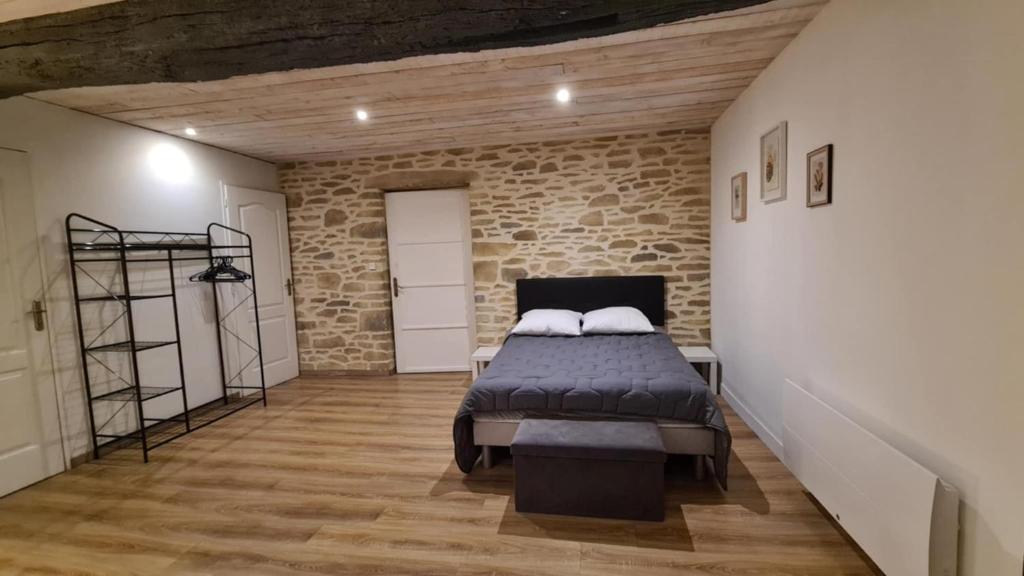 une chambre avec un lit et un mur de briques dans l'établissement Gite 12 personnes avec étang et piscine, à Saint-Hilaire-le-Vouhis