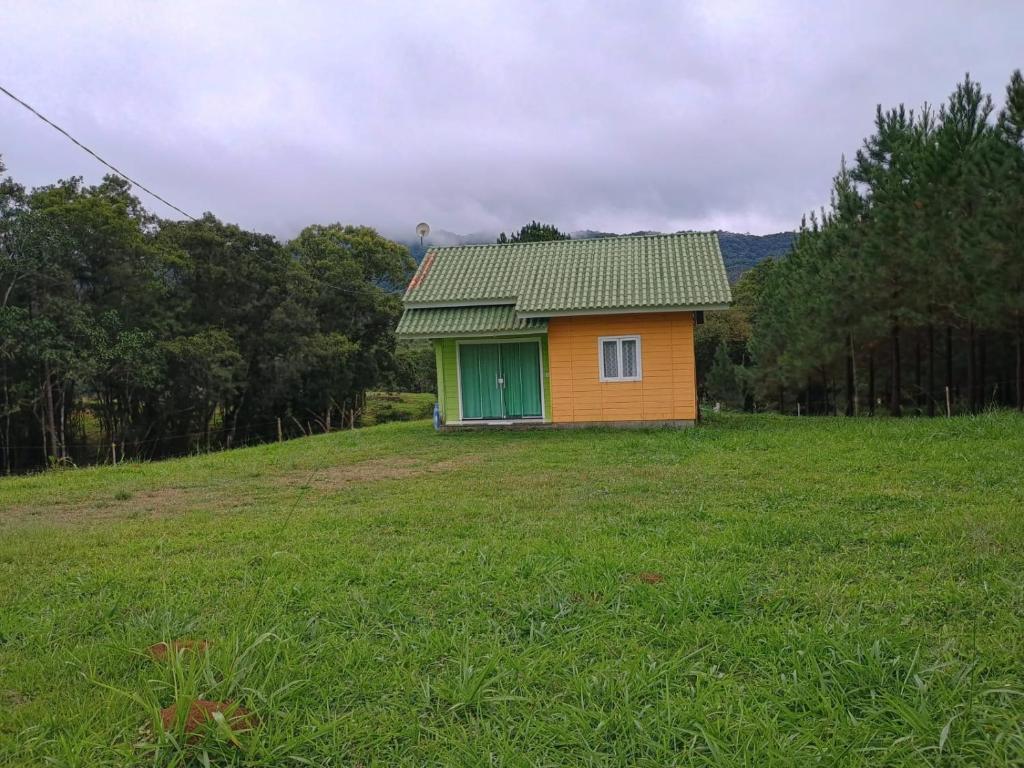 ein kleines Haus auf einem Hügel auf einem Feld in der Unterkunft Casa das Palmeiras in Rio Forcação