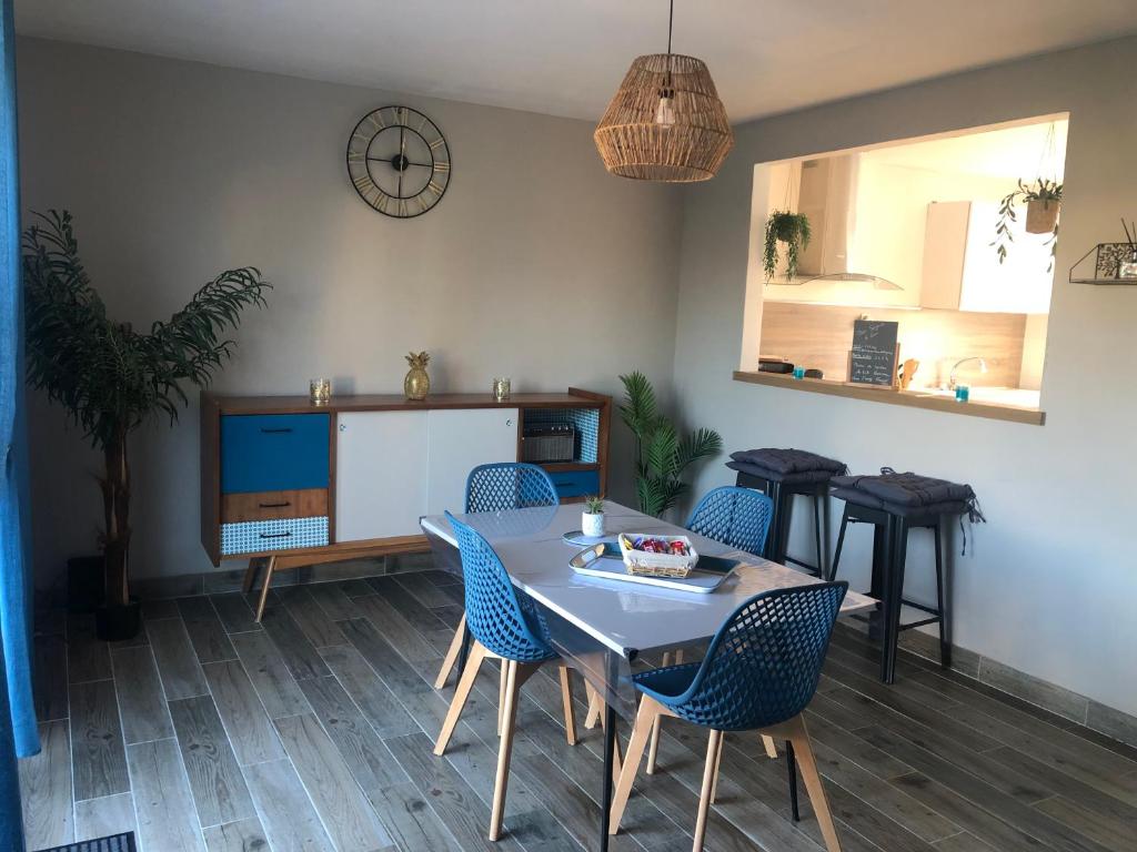 une salle à manger avec une table et des chaises bleues dans l'établissement Gîte détente, à Petit-Berneval