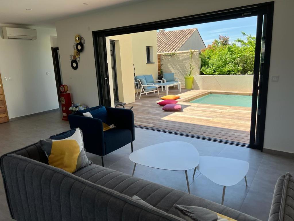- un salon avec un canapé et une piscine dans l'établissement Villa cosy lina, à Gallargues-le-Montueux