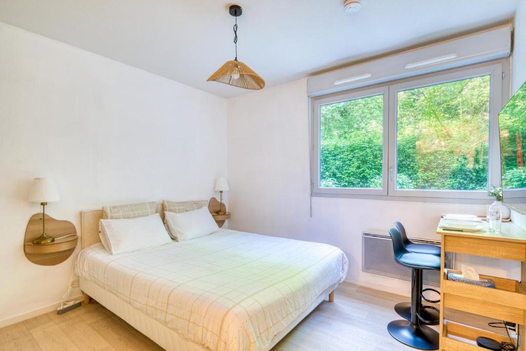 Un dormitorio con una cama y un escritorio y una ventana. en Le Nid Douillet - Caluire - Proximité Lyon, en Caluire-et-Cuire