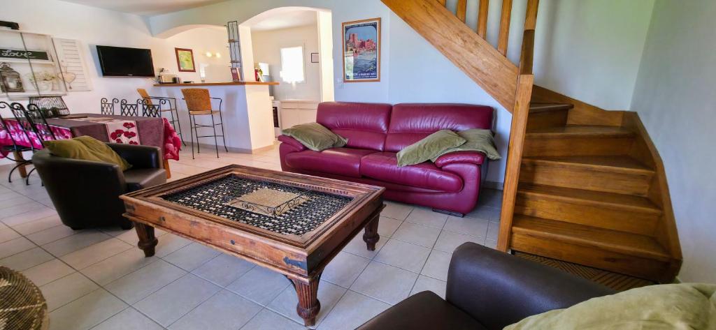 ein Wohnzimmer mit einem lila Sofa und einem Tisch in der Unterkunft Gîte Palma, vue exceptionnelle vallée Provençale in Le Barroux