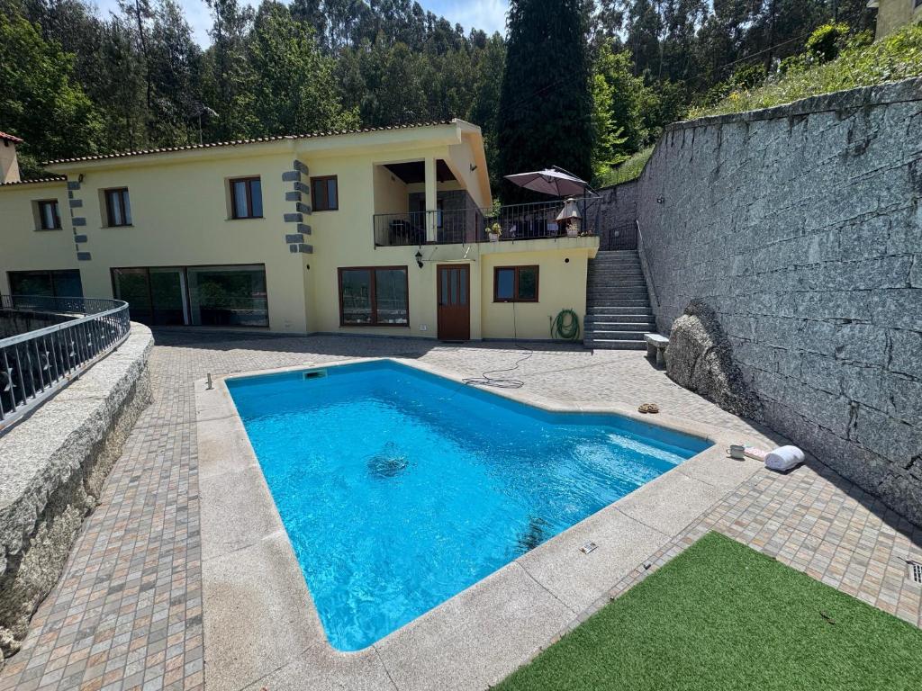 ein Swimmingpool vor einem Haus in der Unterkunft Casa do Recanto by Sé Apartamentos in Vieira do Minho