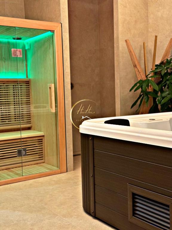 卡塔尼亚Haven Home Suite & Spa的带浴缸的浴室和带绿灯的窗户。