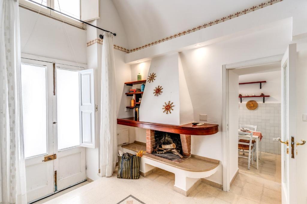 een woonkamer met open haard en een tafel bij U Quardianu - Le Case di Valentina in Gallipoli