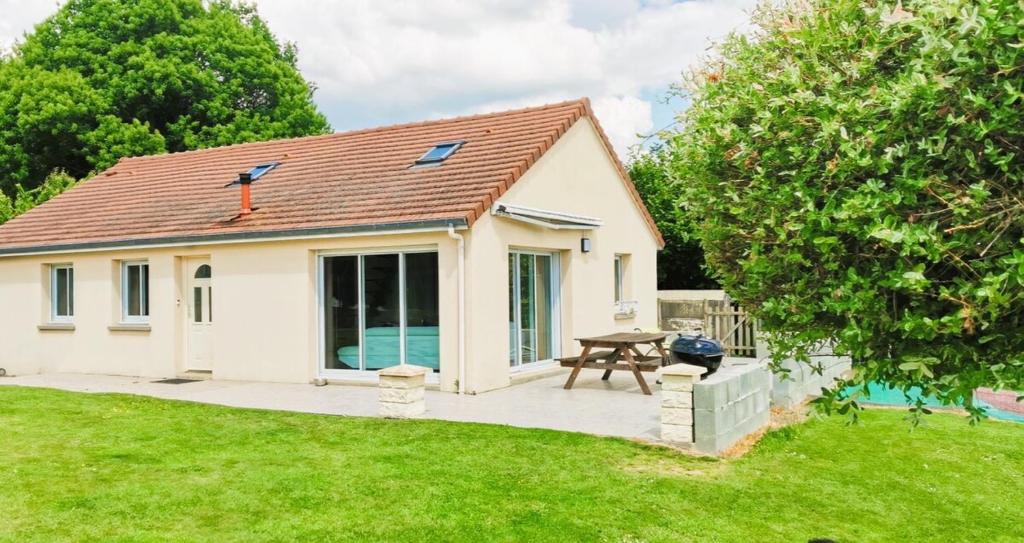 Ce petit cottage blanc dispose d'une table de pique-nique dans la cour. dans l'établissement Maison Bérenger Normandie- 6 personnes, à Saint-Manvieu-Bocage