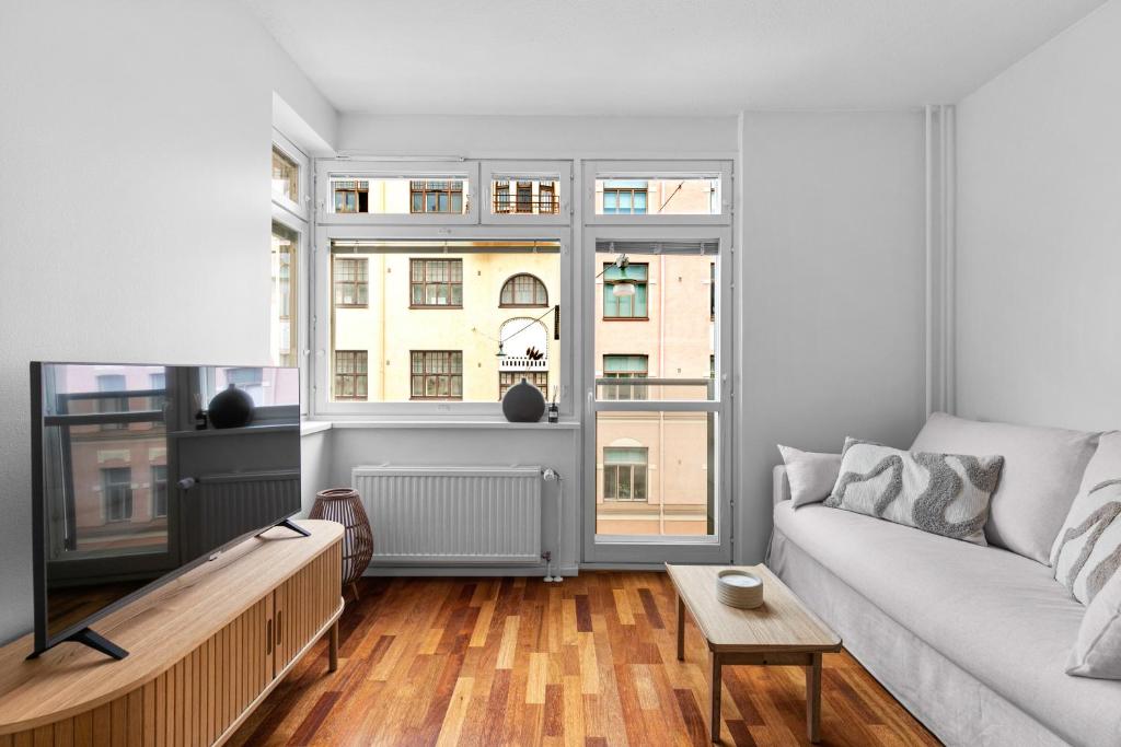 a living room with a couch and two windows at Cozy Studio in City Centre in Helsinki