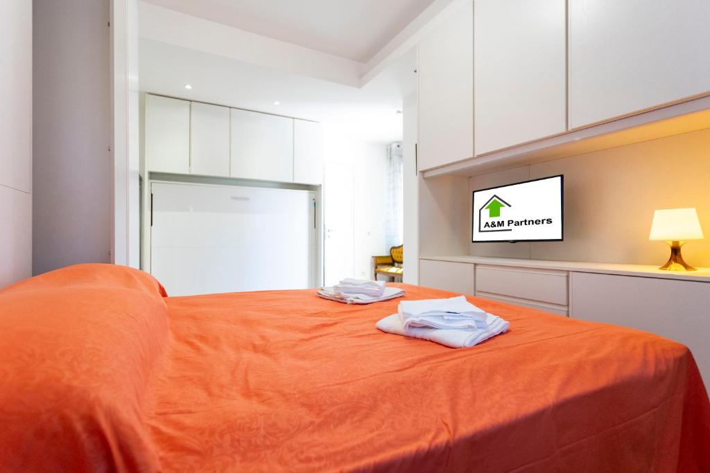 a bedroom with an orange bed with two towels on it at Casa di Patrizia in Rome