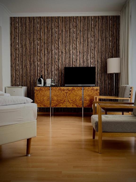 a living room with a television and a couch at Erlanger Hof in Berlin