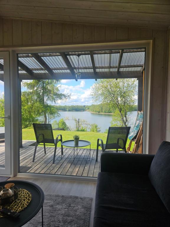 a screened in porch with a view of a lake at Volunge house in Doškonys