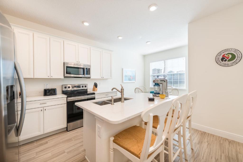 Blue Oasis Cottage With Private Pool Near Disney And Margaritaville Resort & Island H20 Access - 7968Sh في كيسيمي: مطبخ بدولاب بيضاء وقمة بيضاء