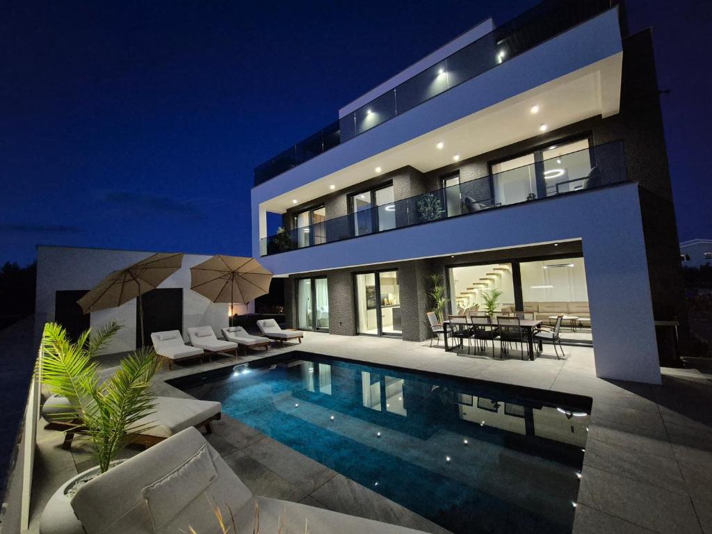 una grande casa con piscina di notte di Luxury Villa Vesper- Private Heated Pool, Hot Tub, Rooftop terrace a Vodice