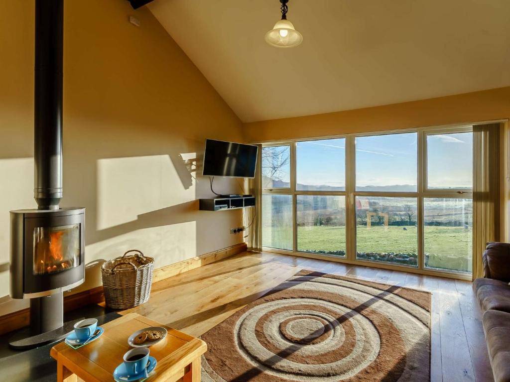 a living room with a fireplace and a large window at 4 Bed in Duddon Valley 89418 in Ulpha