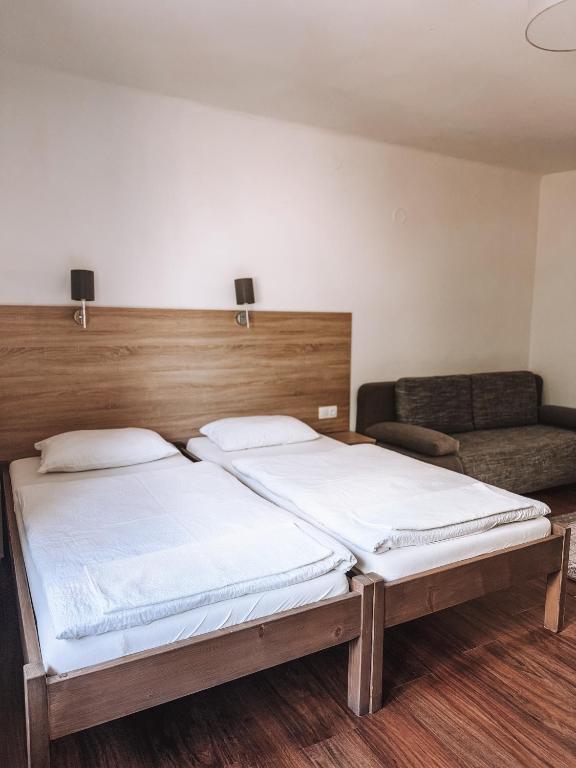 sypialnia z łóżkiem i kanapą w obiekcie Sobri Halászcsárda és Panzió w mieście Baja