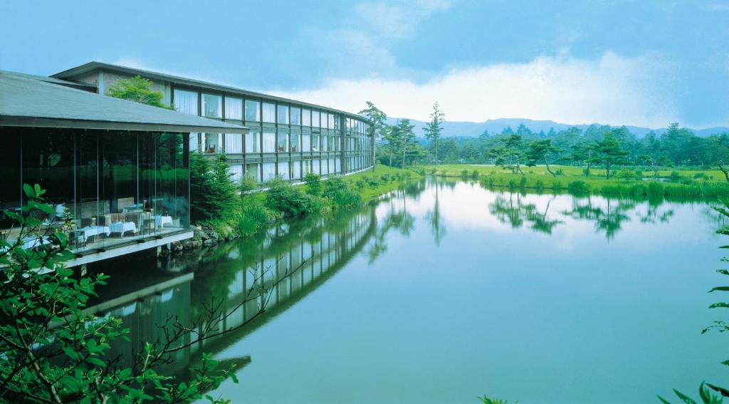 輕井澤的住宿－王子輕井澤酒店，水体旁边的建筑物