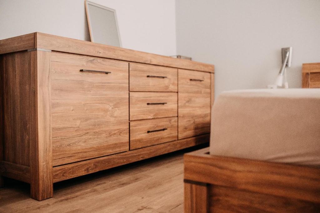 a wooden dresser in a bedroom with a sink at Platz Apartman in Văleni