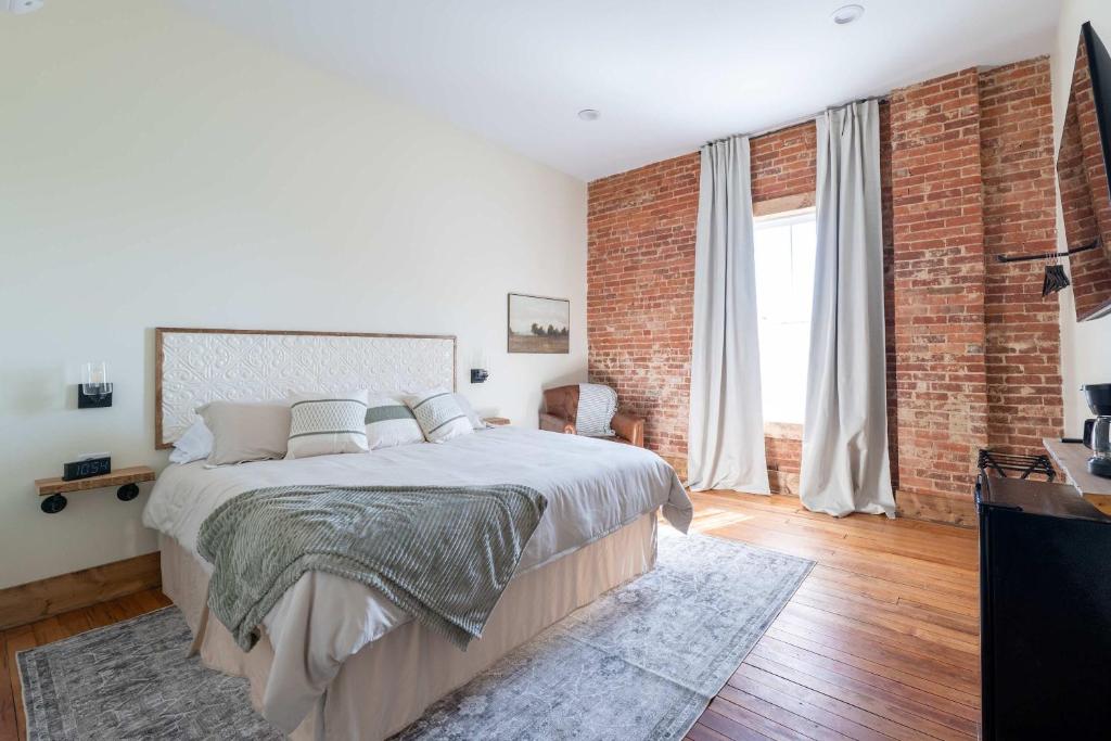 Un dormitorio con una cama grande y una pared de ladrillo. en Courtyard King - Room 3, en Versailles
