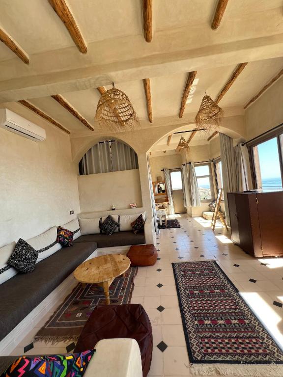 a living room with a couch and a table at SurfAppart Morocco in Tamraght Ouzdar